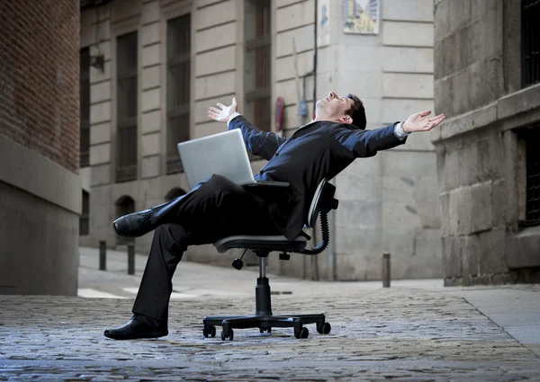 Obchodní muž sedící na kancelářskou židli na ulici s počítačem — Stock fotografie