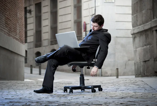 Homme d'affaires fatigué assis sur la chaise de bureau sur la rue dormir — Photo