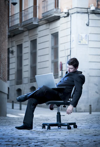 Homme d'affaires fatigué assis sur la chaise de bureau sur la rue dormir — Photo