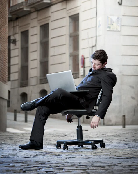 Hombre de negocios cansado sentado en la silla de oficina en la calle durmiendo —  Fotos de Stock