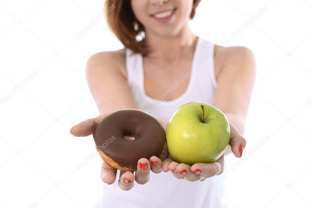 Young sport Woman with Apple and Chocolate Donut in Hands in healthy versus junk food dessert choice isolated on White background