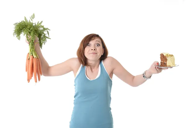 Mujer sosteniendo zanahorias y pastel concepto de nutrición saludable — Foto de Stock