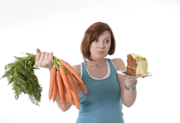 Vrouw met wortelen en taart gezonde voeding concept — Stockfoto