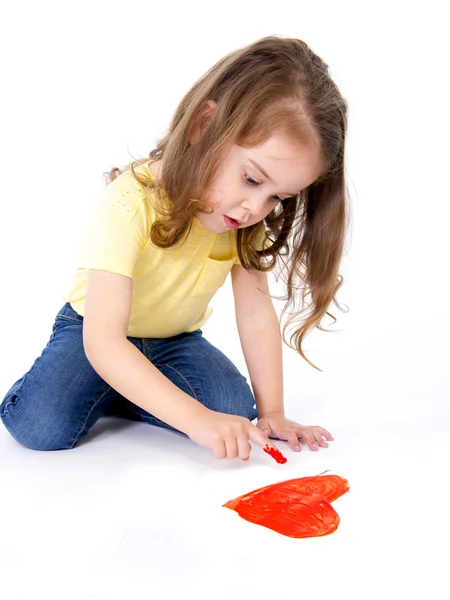Καλλιτεχνική γλυκό κοριτσάκι ζωγραφική με το δάχτυλο, μια κόκκινη καρδιά — Φωτογραφία Αρχείου