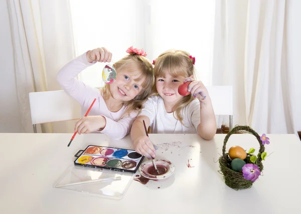 Niñas rubias felices pintando una ventana blanca huevos de Pascua —  Fotos de Stock