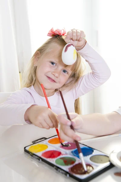 Happy blonded girl painting a easter egg — Stock Photo, Image