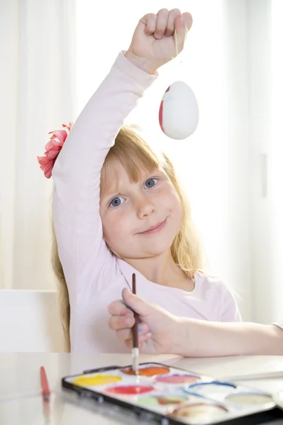 Feliz chica rubia pintando un huevo de Pascua — Foto de Stock