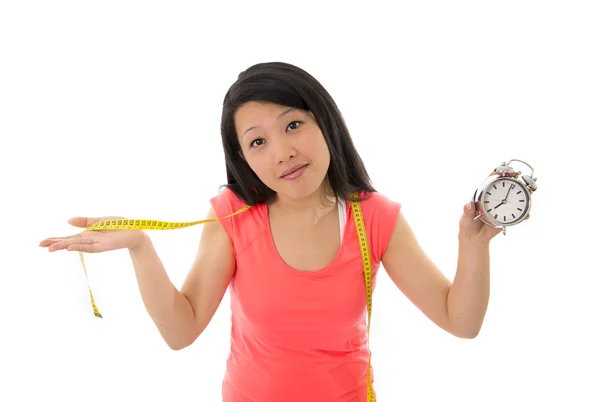 Asiática mulher preocupada em iniciar uma dieta segurando despertador relógio — Fotografia de Stock