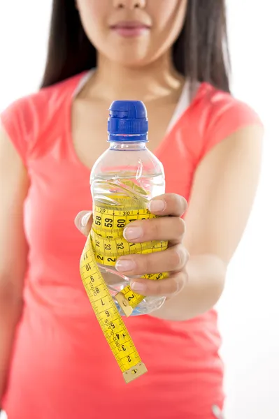 Macro of a bottle of water wrapped in a measuring tape on white background — Stock Photo, Image