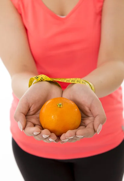 Las manos de la mujer esposadas junto con una cinta métrica con naranja — Foto de Stock