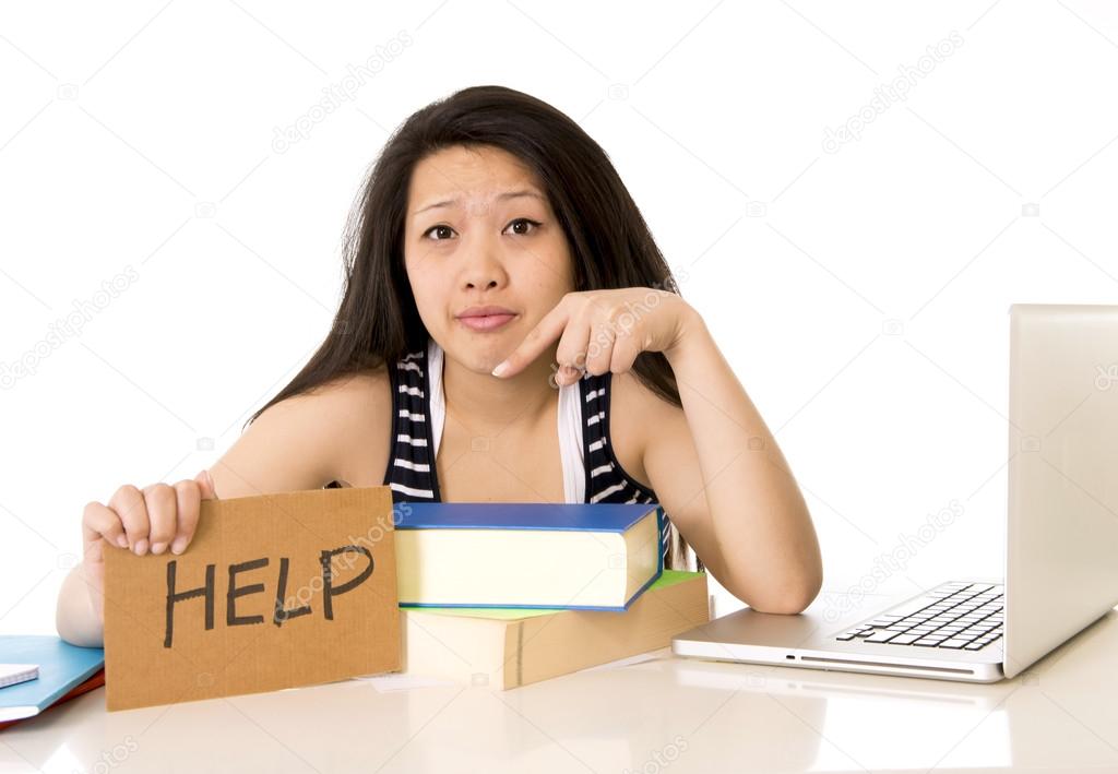 young pretty chinese asian holding a help sign while working on 