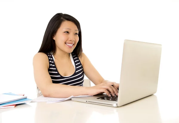 Happy chinese asian woman working on her laptop on white backgro Royalty Free Stock Images