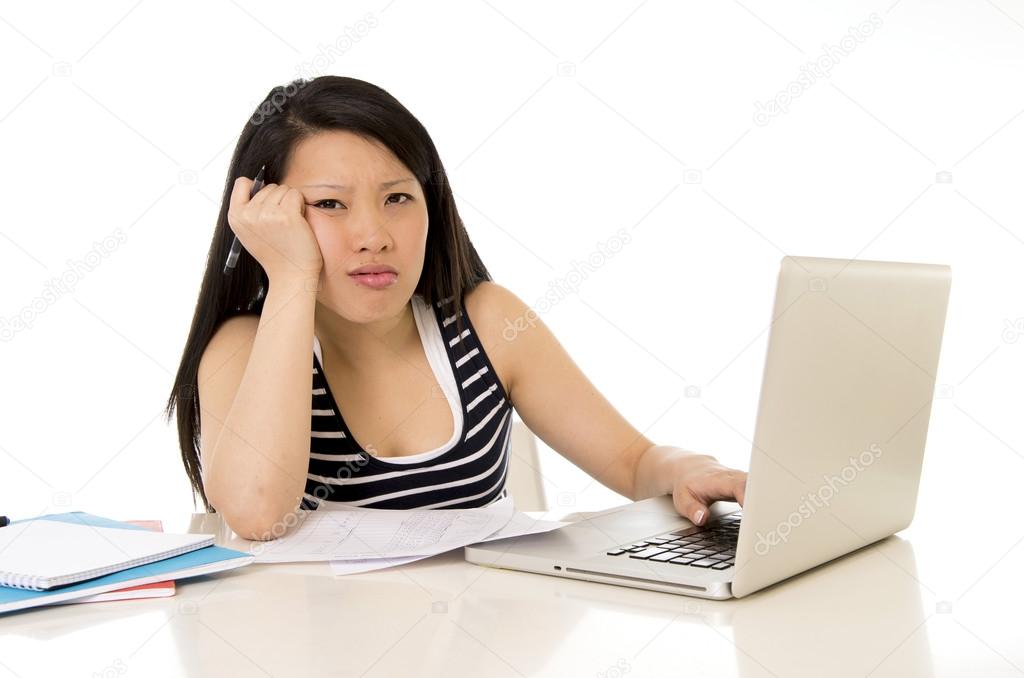 pretty asian woman student overworked on her laptop on white bac