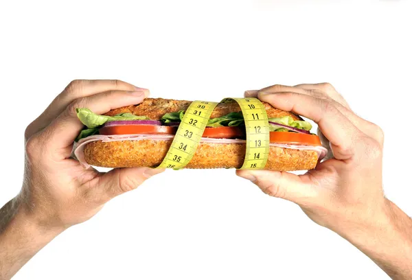 Hands holding Vegetal Sandwich wrapped in measure tape in diet concept — Stock Photo, Image