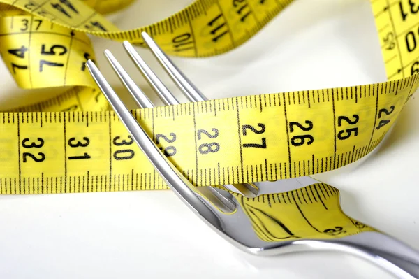 Garpu perak dibungkus dalam ukuran tape dalam konsep diet dan kelebihan berat badan — Stok Foto