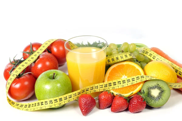 Mix of fresh fruit , vegetables and orange juice wrapped in measure tape — Stock Photo, Image