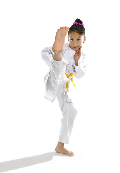 Sweet latin little girl stretching leg in martial arts practice training kick and attack — Stock Photo, Image