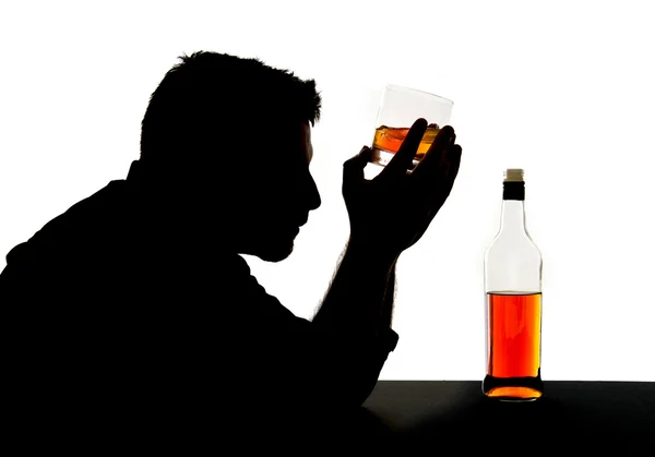 Silhueta de alcoólatra bêbado segurando garrafa de uísque contra a testa sentindo-se deprimido sofrendo de dependência de álcool e alcoolismo problema isolado em fundo branco — Fotografia de Stock