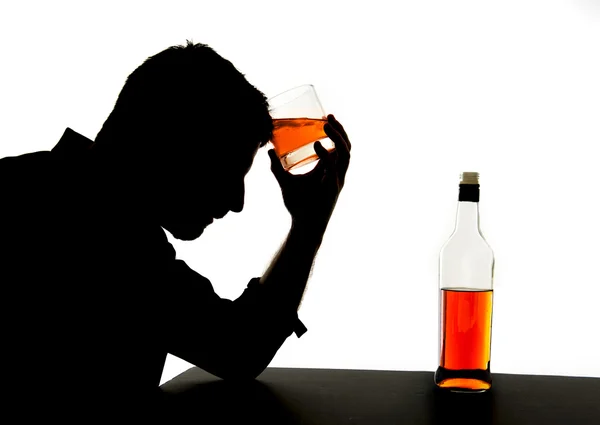 Силуэт алкоголика пьяного человека, держащего бутылку виски на лбу, чувствующего депрессию, страдающего алкоголизмом и проблемы алкоголизма изолированы на белом фоне — стоковое фото