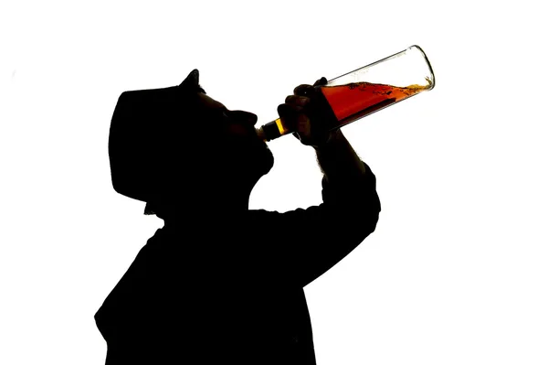 Silueta del alcohólico borracho bebiendo botella de whisky sintiéndose deprimido cayendo en problema de adicción —  Fotos de Stock