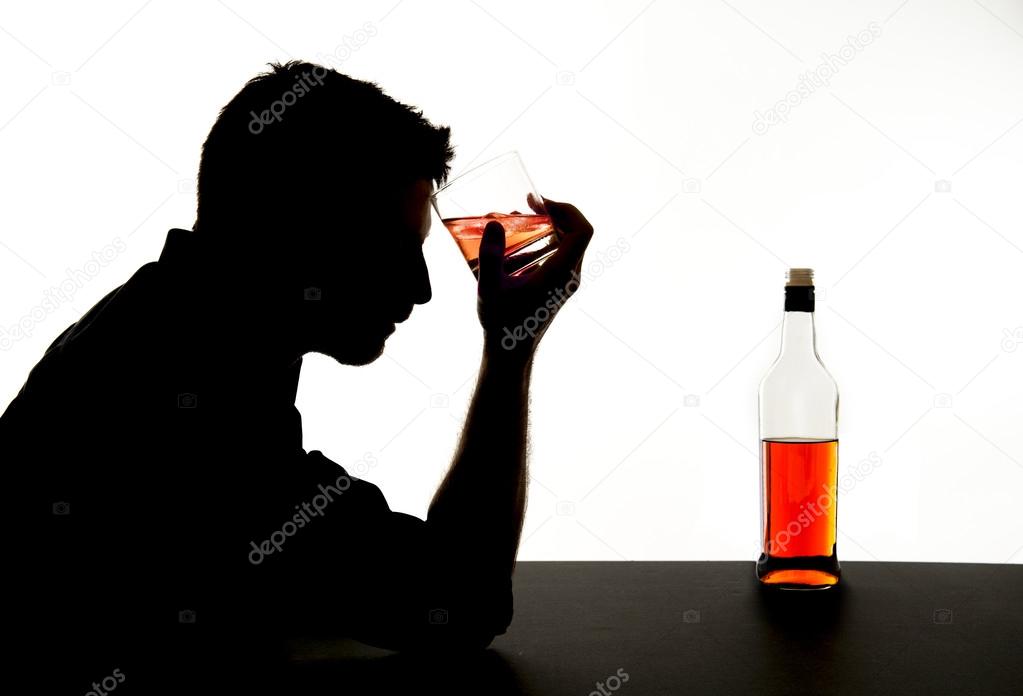 silhouette of alcoholic drunk man drinking whiskey bottle feeling depressed falling into addiction problem