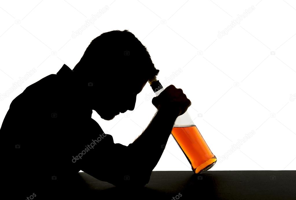 Silhouette Of Alcoholic Drunk Man Holding Whiskey Bottle Against Forehead Feeling Depressed 