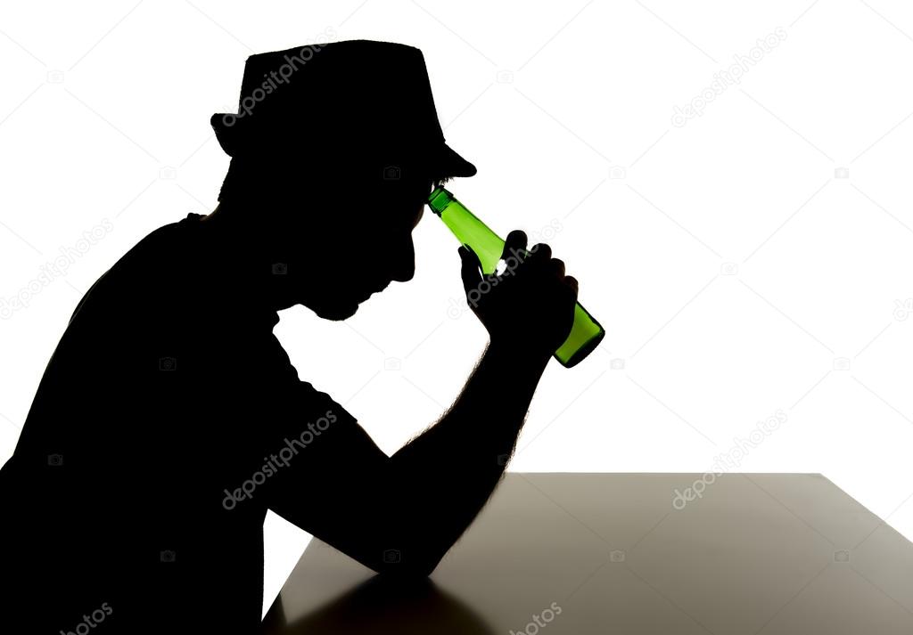 Silhouette of alcoholic drunk man drinking beer bottle feeling depressed falling into addiction problem