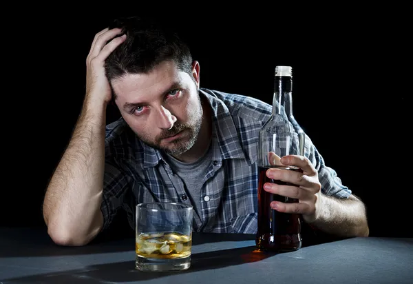 Ubriaco uomo alcolizzato con bicchiere di whisky e bottiglia in dipendenza da alcol e concetto di alcolismo — Foto Stock