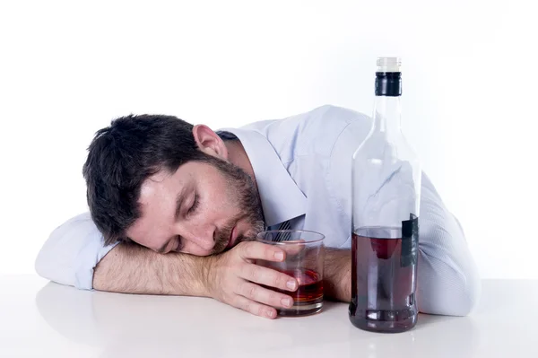 Empresário vestindo camisa azul bêbado na mesa no fundo branco — Fotografia de Stock