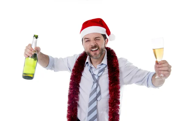 Betrunkener Geschäftsmann trinkt Champagner mit Weihnachtsmütze auf weißem Hintergrund Stockbild