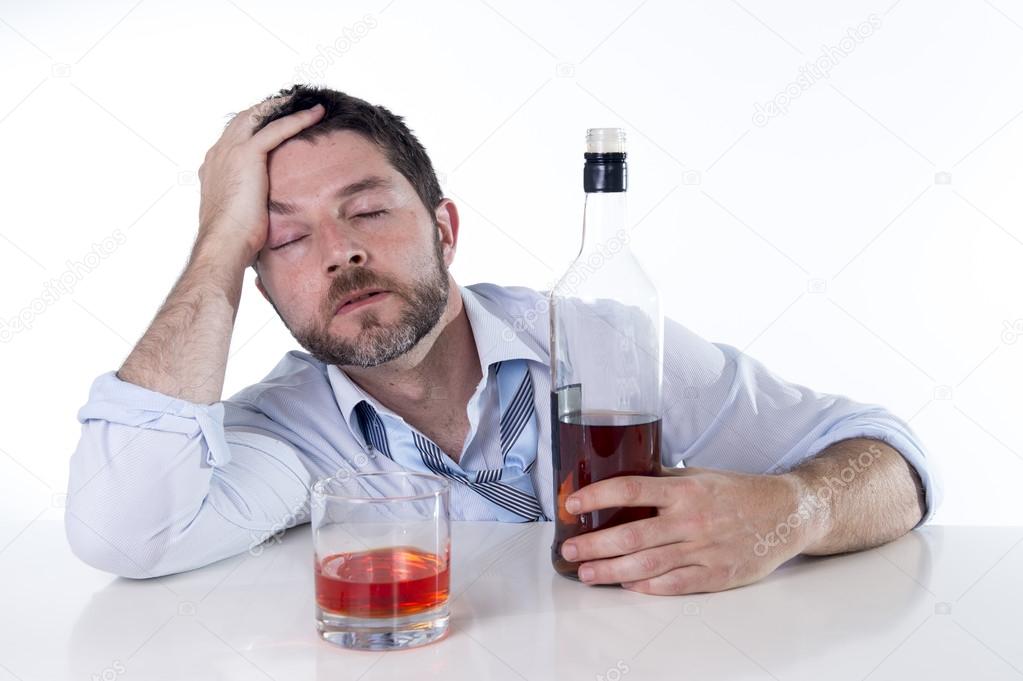 Businessman wearing blue shirt drunk at desk on white background