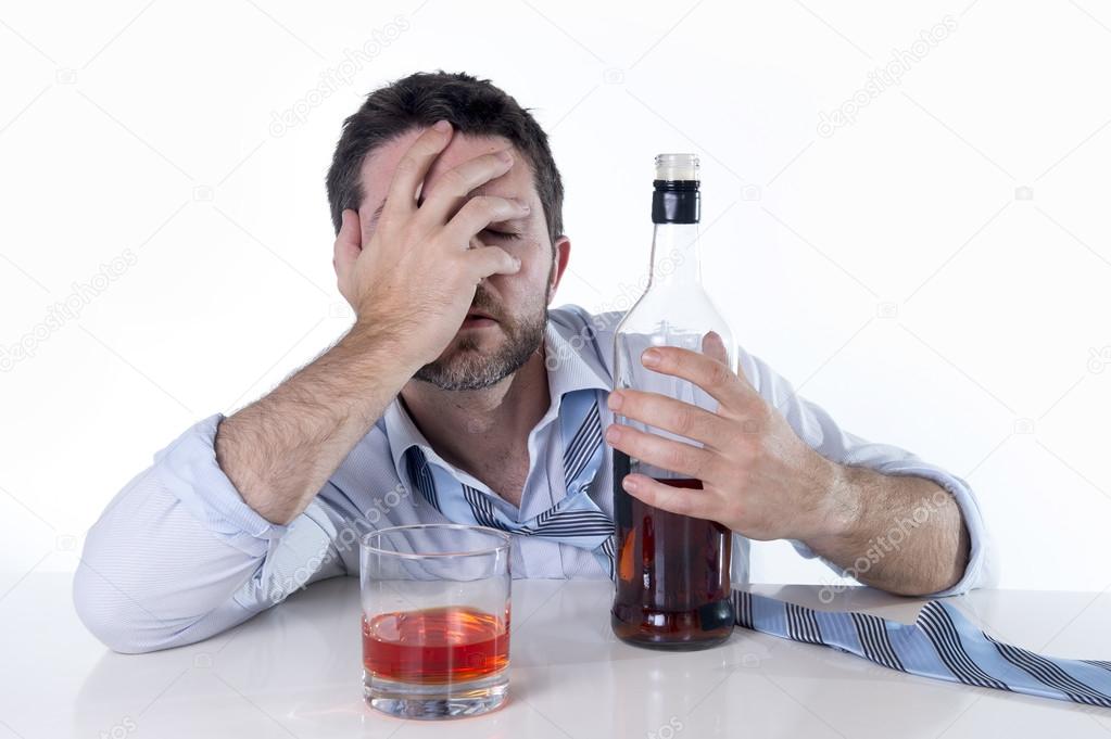 Businessman wearing blue shirt drunk at desk on white background