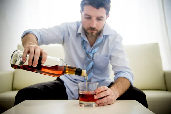 Businessman wearing blue shirt drunk at desk on white background — Stock Photo, Image