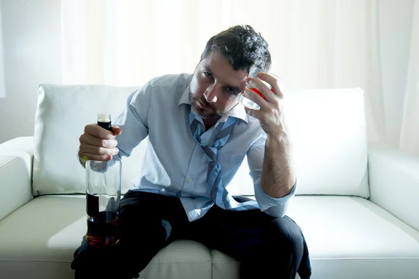 Empresário vestindo camisa azul bêbado na mesa no fundo branco — Fotografia de Stock