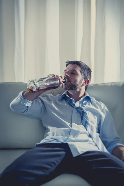 Businessman wearing blue shirt drunk at desk on white background — Stock Photo, Image