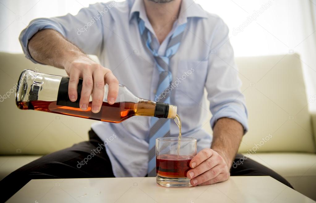 Businessman wearing blue shirt drunk at desk on white background