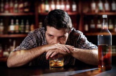 Alcoholic drunk man thoughtful on alcohol addiction at bar of pub clipart