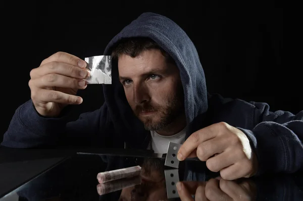 Jovem viciado em drogas sozinho no capuz prepara linhas de cocaína — Fotografia de Stock