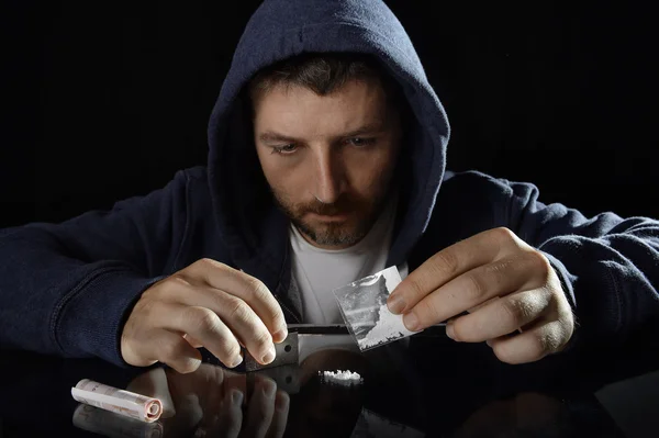 Jovem viciado em drogas sozinho no capuz prepara linhas de cocaína — Fotografia de Stock