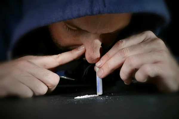 Drug addict man on hood snorting cocaine line with rolled banknote — Stock Photo, Image