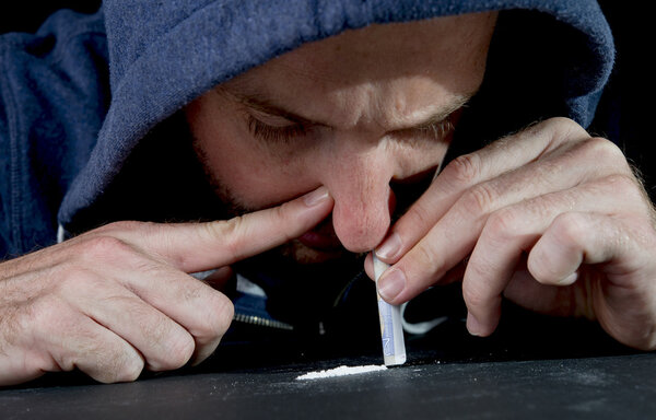 Sad man doing sniffing cocaine at home on his own