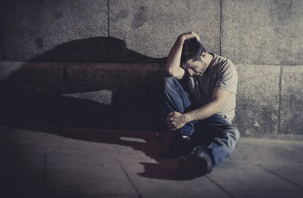 Depressziós fiatal ember ül utcai föld árnyéka a betonfal Stock Kép