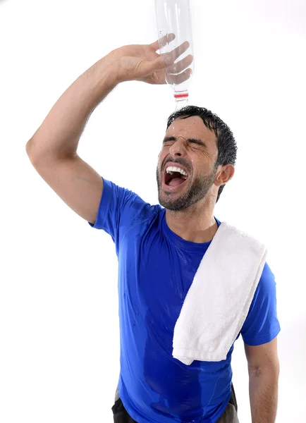 Joven hombre deportivo atractivo y atlético agotado vertiendo agua en su cara — Foto de Stock