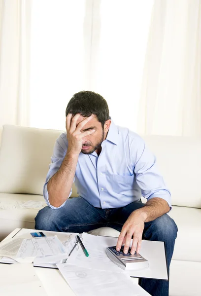 Uomo d'affari latino preoccupato di pagare le bollette sul divano — Foto Stock