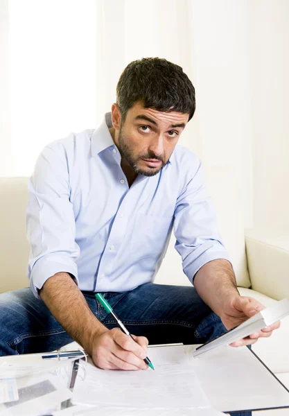 Hombre de negocios latino preocupado pagando facturas en sofá — Foto de Stock