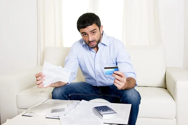 Hombre de negocios latino preocupado pagando facturas en sofá —  Fotos de Stock