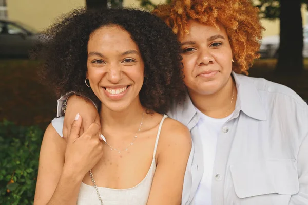 Tutup potret indah indah lesbian Afrika Amerika pasangan berpelukan di sekitar lanskap jalan kota di musim panas. Konsep komunitas LGBT. Teman-teman wanita tersenyum menikmati saat-saat cinta bersama — Stok Foto