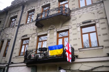TİLİSİ, GEORGIA - 11 Mart 2021. Ukrayna ve Gürcistan bayrakları Ukrayna 'yı desteklemek için evlere, binalara, apartmanların balkonlarına asılıyor.