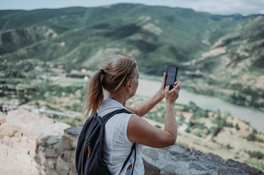 Olgun yaşlı turist yazın gözlem güvertesinde fotoğraf çeker. Emekli insanlar yaz tatili, aktif yaşam tarzı konsepti. 