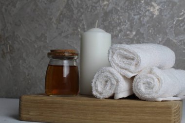 Vücut masajı için yağ beyaz mum havluları salyangoz salyangoz tahta tepside gri arka plan görünümlü. Spa rahatlama masajı. Vücut bakımı.